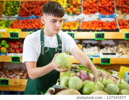 Portrait of a guy seller working in a vegetable store Portrait of a guy seller working in a vegetable store 127345977