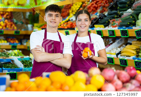 Portrait of friendly salespeople in fruit section of grocery store Portrait of friendly salespeople in fruit section of grocery store 127345997