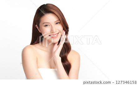 A beautiful young Asian woman with clean, fresh skin against a white background. Skincare, facial treatment, cosmetology, beauty, and spa. An elegant portrait of an Asian woman. 127346158