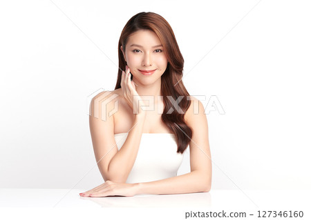 A beautiful young Asian woman with clean, fresh skin against a white background. Skincare, facial treatment, cosmetology, beauty, and spa. An elegant portrait of an Asian woman. 127346160