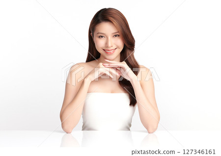 A beautiful young Asian woman with clean, fresh skin against a white background. Skincare, facial treatment, cosmetology, beauty, and spa. An elegant portrait of an Asian woman. 127346161