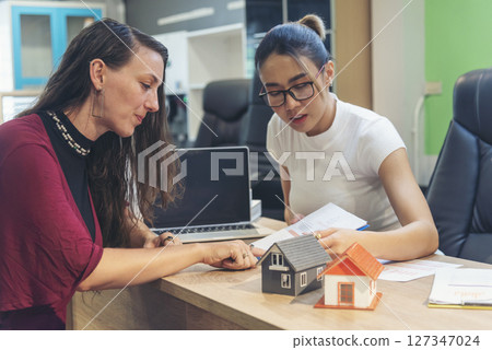 Team diversity women selling house real estate agent at office desk. Women working home insurance mortgage sale apartment realtor dealership. Businesswoman real estate house agent discuss to customer Team diversity women selling house real estate agent at office desk. Women working home insurance mortgage sale apartment realtor dealership. Businesswoman real estate house agent discuss to customer 127347024
