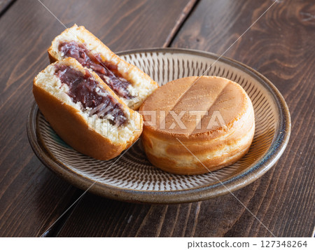A cross section of the baked confectionery "Oyaki." A Japanese confectionery made of dough wrapped around red bean paste. It is also called obanyaki or imagawayaki. A cross section of the baked confectionery "Oyaki." A Japanese confectionery made of dough wrapped around red bean paste. It is also called obanyaki or imagawayaki. 127348264