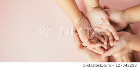 Parents and kid holding empty hands together isolated on color background. Family day celebrating togetherness and support. 127348288