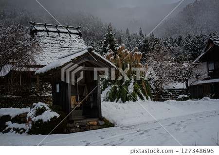 這張照片是在京都南丹市美山町被雪覆蓋的茅草屋頂村拍攝的。 127348696