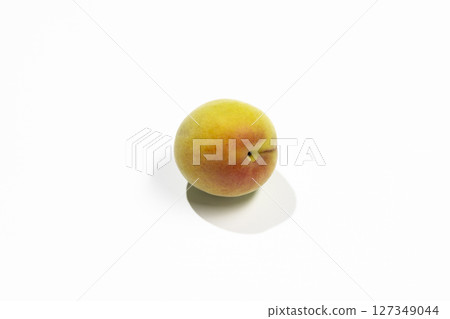 Unripe plums and copy space on white background 127349044