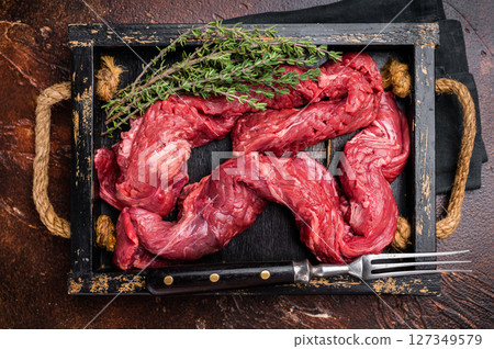 Beef cut Machete Skirt Steak, raw marble meat in wooden tray. black background. top view 127349579