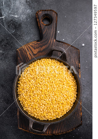 Ptitim pasta, Israeli couscous in a skillet. black background. top view 127349597