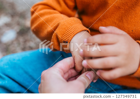 Close up of father and boy observing bug during nature walk Close up of father and boy observing bug during nature walk 127349731