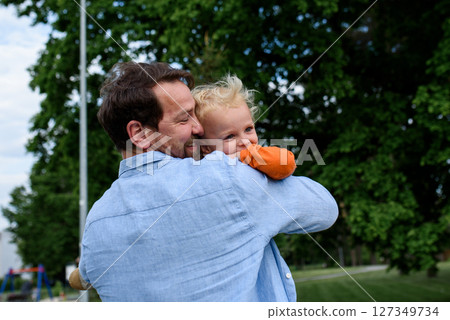Portrait of dad hugging little son, enjoying time together Portrait of dad hugging little son, enjoying time together 127349734