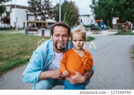 Father playing with toddler son outdoors in park Father playing with toddler son outdoors in park 127349740