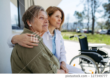 Female doctor spending time with resident of nursing home. Female doctor spending time with resident of nursing home. 127349777