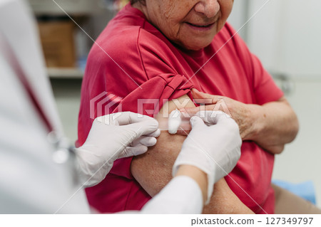 Elderly patient being vaccinated by doctor. 127349797