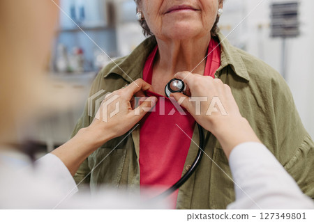 Geriatrician doctor examining elderly patient with stethoscope. Geriatrician doctor examining elderly patient with stethoscope. 127349801