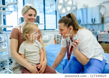 Doctor listening little boy's heartbeat and breathing during preventive medical checkup. Doctor listening little boy's heartbeat and breathing during preventive medical checkup. 127349820