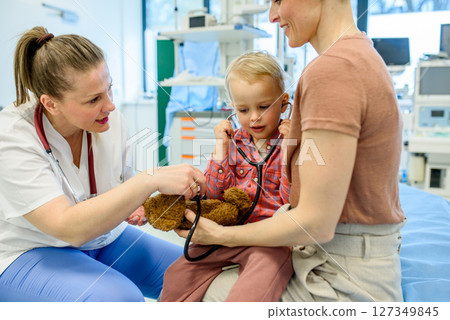 Little boy trying pediatrician's stethoscope during medical examination. 127349845