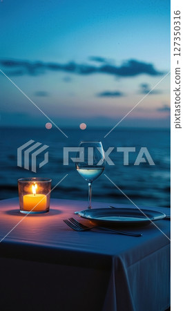 Candlelit Seaside Dinner Table for One at Twilight with Ocean Horizon 127350316