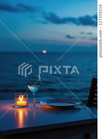 Candlelit Seaside Dinner Table for One at Twilight with Ocean Horizon 127350319