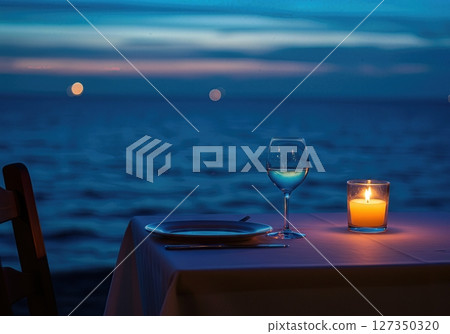 Candlelit Seaside Dinner Table for One at Twilight with Ocean Horizon 127350320
