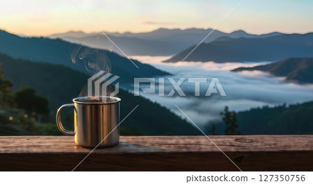 Steaming Coffee Mug Overlooking Misty Mountain Landscape at Sunrise 127350756