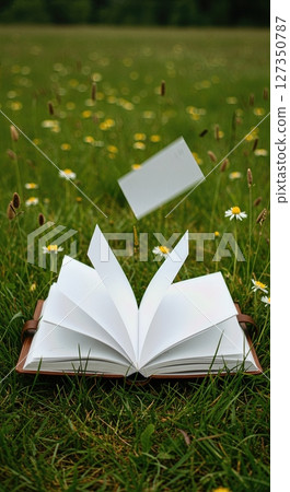 Open Travel Journal with Fluttering Pages in Wildflower Meadow 127350787