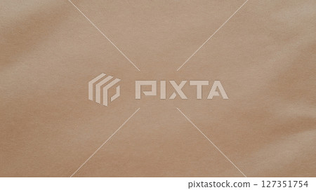 Brown craft paper background with soft folds, close-up texture. Minimal natural surface, flat lay. 127351754