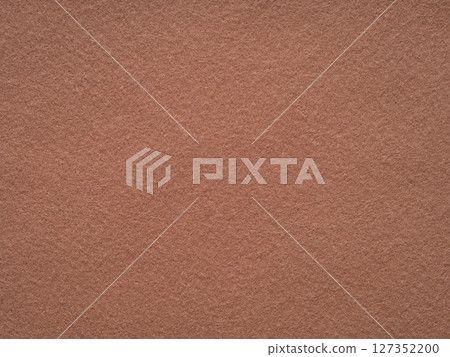 An inviting landscape of terracotta felt, the surface exudes the warmth of earthenware in the soft afternoon glow 127352200