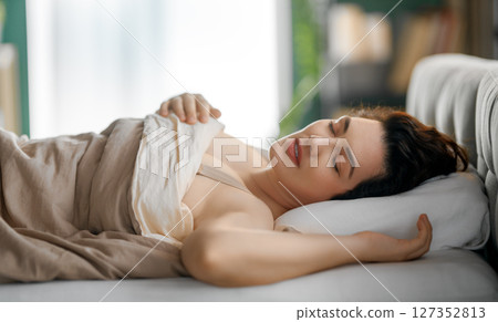 woman is sleeping in the bedroom 127352813