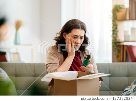 Woman is unpacking cardboard Woman is unpacking cardboard 127352824