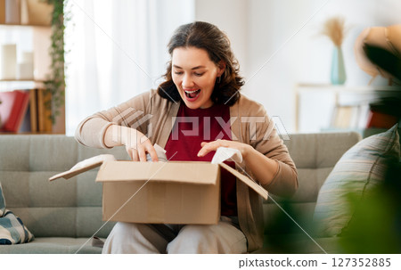 Woman is unpacking cardboard Woman is unpacking cardboard 127352885