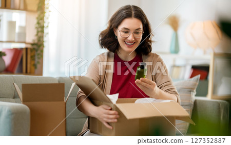 Woman is unpacking cardboard 127352887