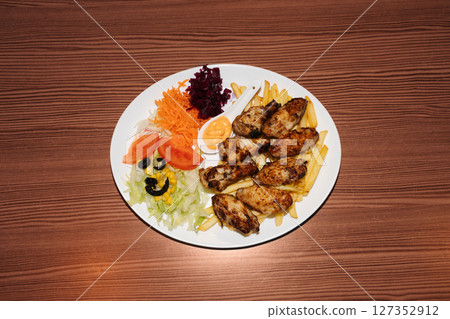 Turkish kebab plate with fries, vegetables and chicken. Delicious freshly prepared meal, perfect for menus, restaurants, or food delivery concepts. Turkish kebab plate with fries, vegetables and chicken. Delicious freshly prepared meal, perfect for menus, restaurants, or food delivery concepts. 127352912