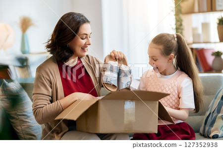 Mother and daughter are unpacking cardboard 127352938