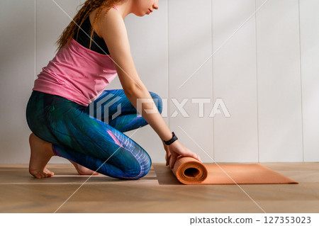 woman is rolling yoga mat 127353023