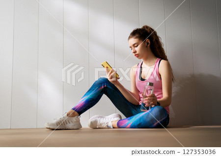 Woman in fashionable sportswear is doing exercise. Woman in fashionable sportswear is doing exercise. 127353036
