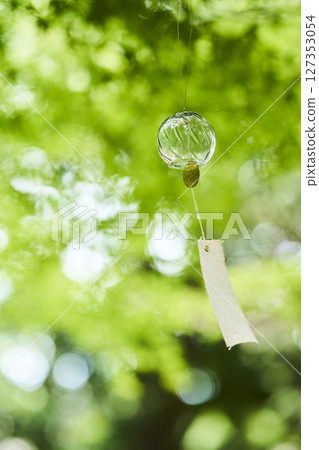 Wind chimes swaying in the wind under the summer sunlight Wind chimes swaying in the wind under the summer sunlight 127353054