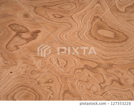 Swirling patterns of rich sienna and subdued tan create a mesmerizing veneer surface, showcasing the unique beauty of burl wood Swirling patterns of rich sienna and subdued tan create a mesmerizing veneer surface, showcasing the unique beauty of burl wood 127353228