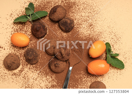 Chocolate truffles with kumquat and mint on a light background Chocolate truffles with kumquat and mint on a light background 127353804