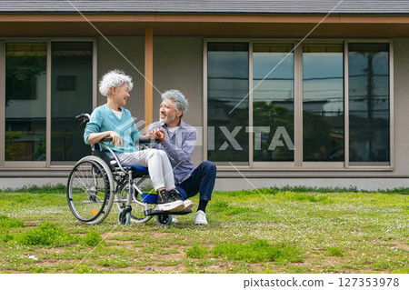 坐在輪椅上的老年夫妻在家門前聊天 127353978
