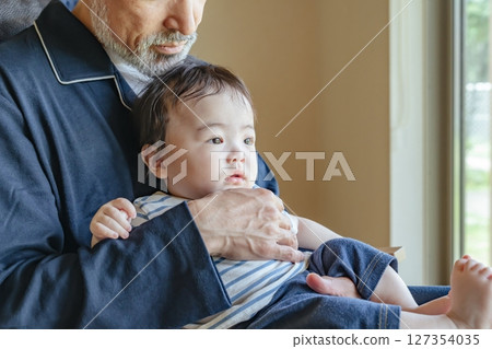Senior man holding a baby Senior man holding a baby 127354035
