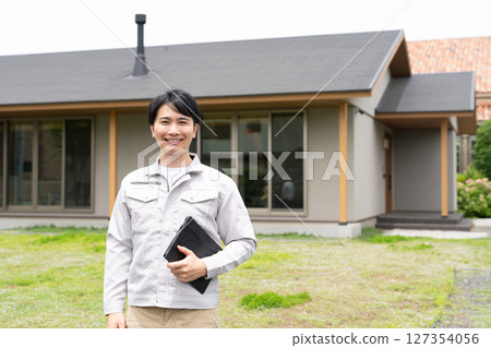 站在房子前的男工人 127354056