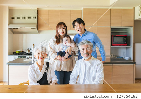 Smiling three-generation family surrounding a baby Smiling three-generation family surrounding a baby 127354162