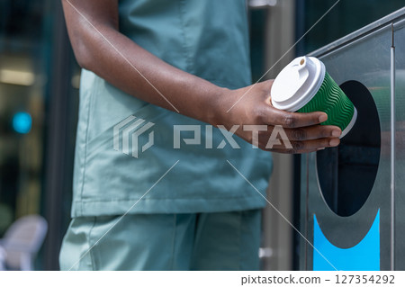 Close up picture of a woman throwing waste to the sorting waste bin 127354292