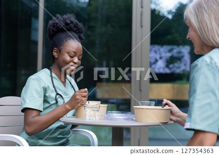 Doctors colleagues having lunch together in the cafe Doctors colleagues having lunch together in the cafe 127354363