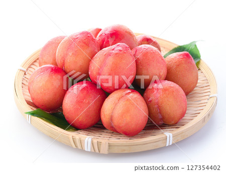 白色背景下的酸甜可口的李子（早期） 127354402