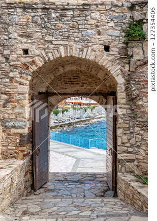 Kusadasi castle gate opens to Aegean Sea view in Izmir, Turkey, clear skies, daytime Kusadasi castle gate opens to Aegean Sea view in Izmir, Turkey, clear skies, daytime 127354406