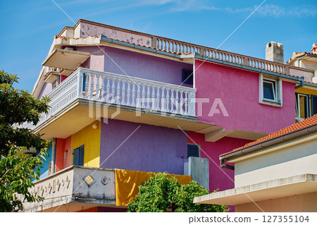 Colorful residential building with balconies and vibrant painted walls Colorful residential building with balconies and vibrant painted walls 127355104