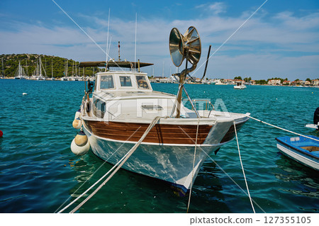 Fishing boat moored in turquoise Adriatic sea near harbor Fishing boat moored in turquoise Adriatic sea near harbor 127355105