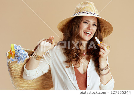 happy stylish woman in blouse and shorts isolated on beige 127355244