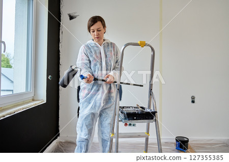 Person Holding Paint Roller During Apartment Renovation Person Holding Paint Roller During Apartment Renovation 127355385